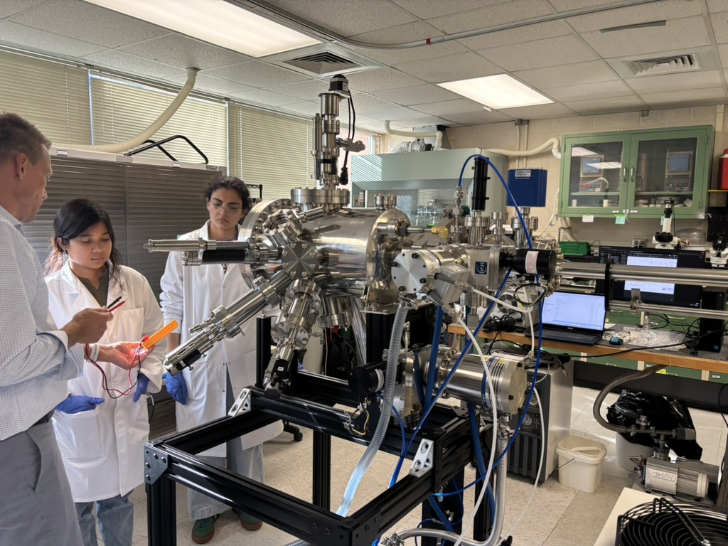 Lab members examining the installed PVD system
